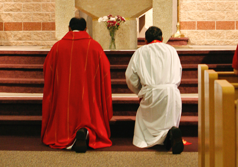 Fr. John and Fr. Ravi genuflecting before altar
